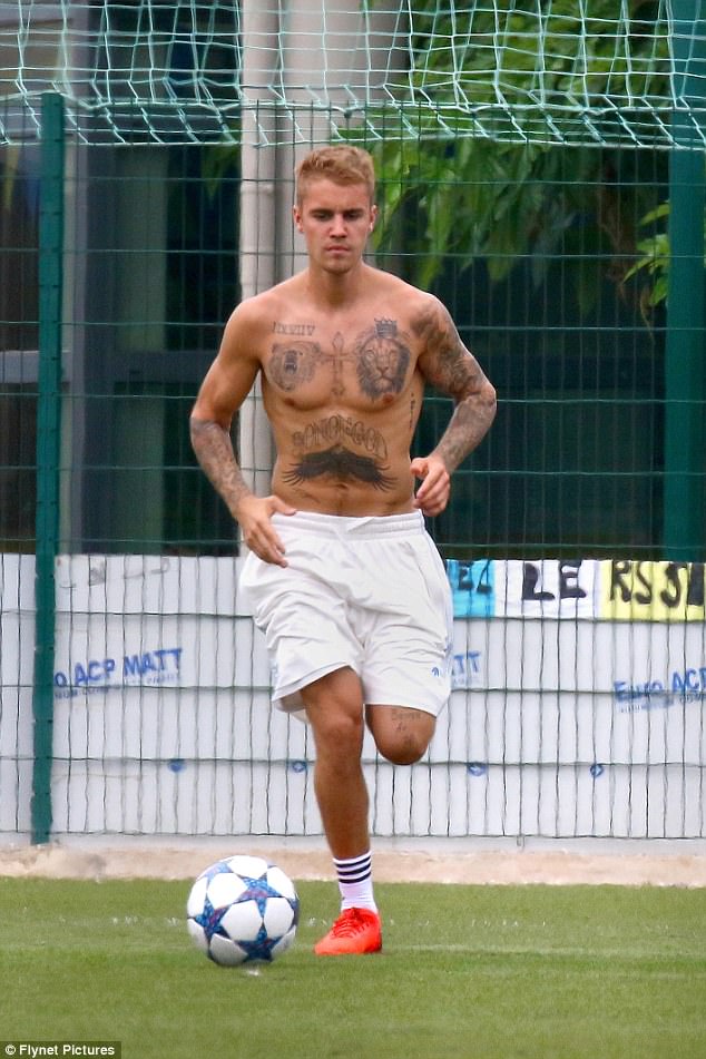 Pecs appeal! Justin Bieber shows off his sculpted torso as he kicks soccer ball around in France