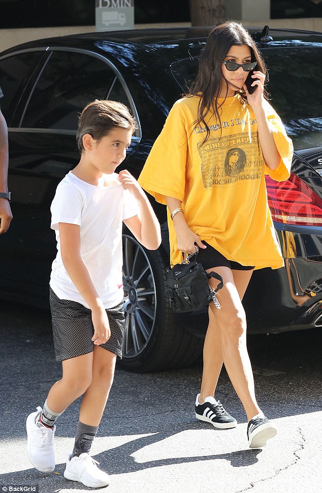 Kourtney Kardashian shows off her Legs in Vintage oversized Yellow Shirt