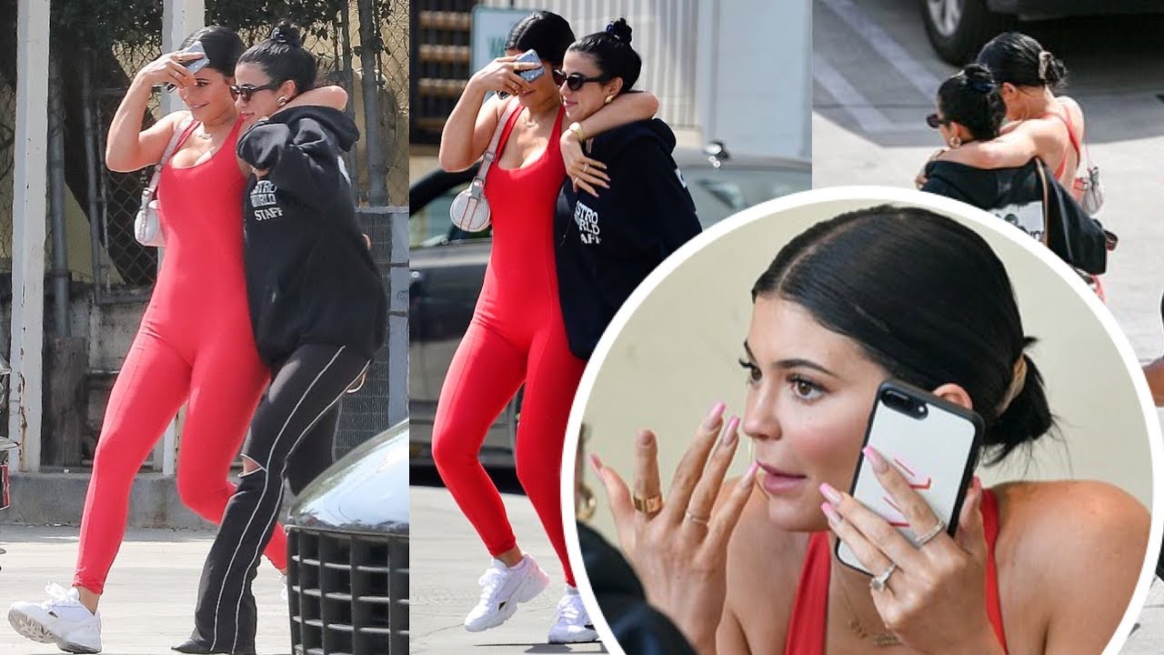 Kylie Jenner in red jumpsuit and swept her dark hair back into a bun