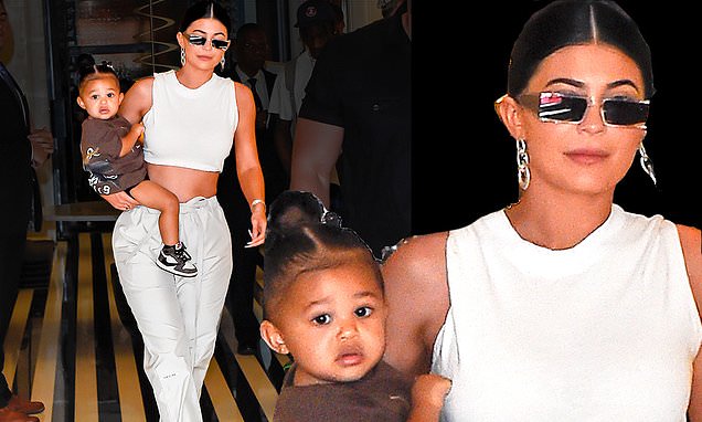 Kylie Jenner flaunts her toned tummy in a creamy crop top with Stormi on her hip